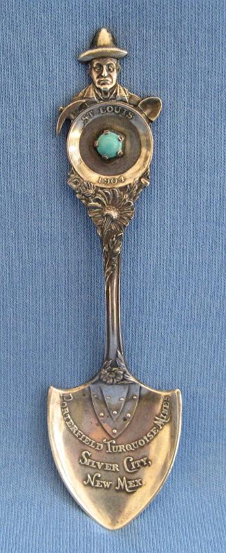 Souvenir Mining Spoon Porterfield Turquoise Mines Silver City NM.JPG - SOUVENIR MINING SPOON PORTERFIELD TURQUOISE MINES SILVER CITY NM - Sterling silver shovel-shaped spoon, memento from New Mexico Mines and Minerals display at 1904 St. Louis World's Fair Louisiana Purchase Exposition, marked in bowl PORTERFIELD TURQUOISE MINES, SILVER CITY, NEW MEX.; miners pan on the top of the handle with a miner, shovel, and pick, and marked ST. LOUIS 1904 in pan along with a piece of turquoise laid in;  reverse marked  with Mechanics Sterling Co. makers mark and Sterling; length 4 in., weighs 12 grams  [At the 1904 Louisiana Purchase Exposition in St. Louis, the Porterfield Turquoise Mines Company displayed a replica of a New Mexico turquoise mine where these souvenir spoons with a piece of their turquoise were sold as mementos.  The Porterfield Mines were in the Burro Mountain District just south of Silver City, NM in an area known as Tyrone today.  M. W. Porterfield, known as the turquoise king and the father of turquoise mining on a commercial scale, sent several tons of ore from his turquoise mines in New Mexico for the erection of a turquoise mine at the 1904 St. Louis Expo.  Porterfield was executive commissioner of the New Mexico exhibits at the World's Columbian Exposition at Chicago in 1893 as well as the Omaha Exposition in 1898 and the 1904 Louisiana Purchase Exposition, preparing all the exhibits from the Territory.  Melvin W. Porterfield was born September 6, 1855 at Fairfield, Illinois, the son of William H. and Elizabeth Porterfield.  He was reared and educated at Fairfield before receiving a graduate degree from the National Normal University at Lebanon, Ohio, in the class of 1877.  He moved to Silver City in the New Mexico Territory in 1888 where he and his brother W. C. Porterfield established a drug business. Until 1888 practically all the turquoise of the world came from the empire of Persia. In that year Porterfield, while making excavations around Silver City in ancient Indian ruins, found several turquoise leads and unfinished specimens of the stone in sufficient quantities to develop the property.  Thus was inaugurated the first turquoise mining in the United States under modern conditions and Porterfield became the pioneer in that industry. By 1893 his mines were supplying nearly three-fourths of the turquoise sold annually throughout the world.  Porterfield served as a probate judge in Grant County from 1890 to 1892 and married Carrie Steely in Silver City in 1898 fathering one daughter, Ann Elizabeth.  He died in 1927 and is buried in Silver City.]